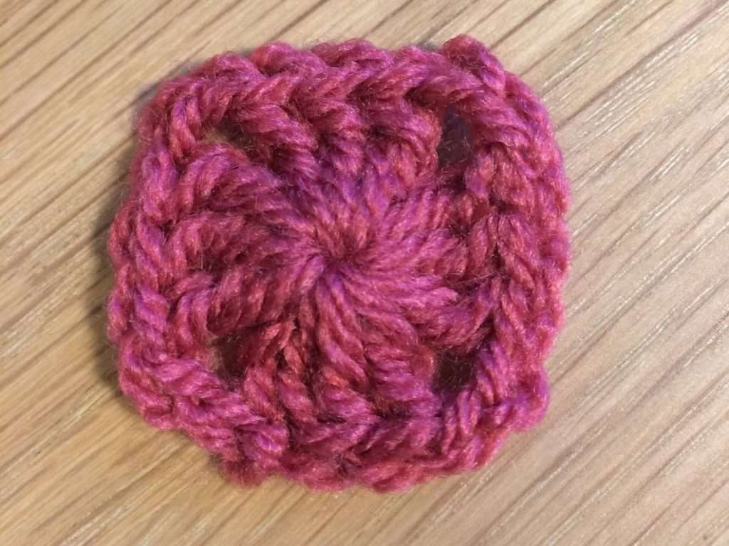 Round 1 of the Summer Fruits Granny Square with raspberry coloured yarn