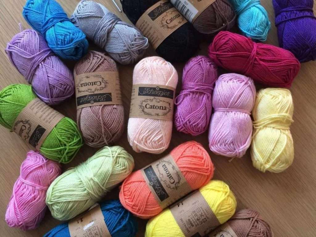 Balls of cotton yarn in a range of colours on a table
