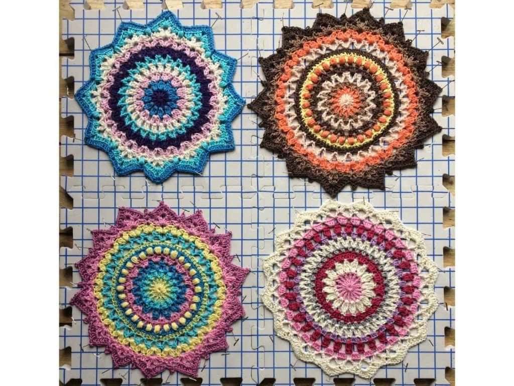 Four different crochet mandalas being blocked on a blocking board
