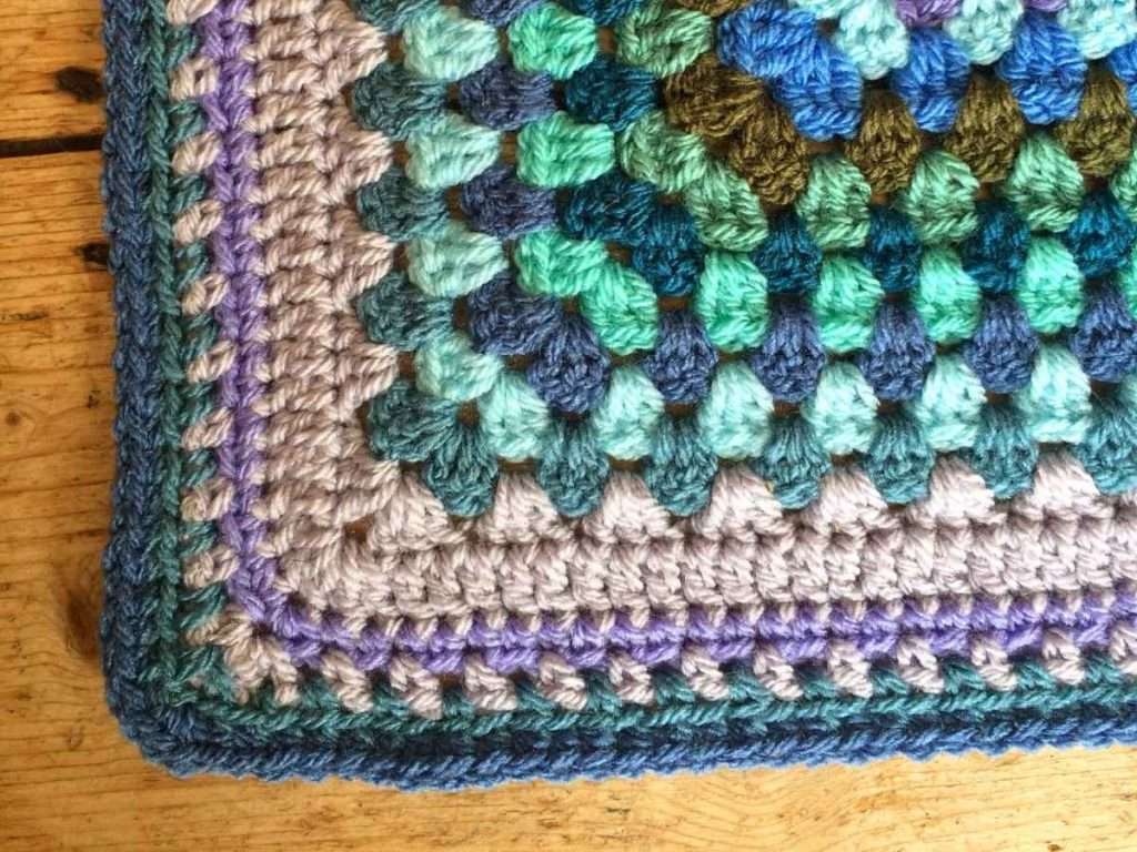 Close up of crochet border in grey and teal colours