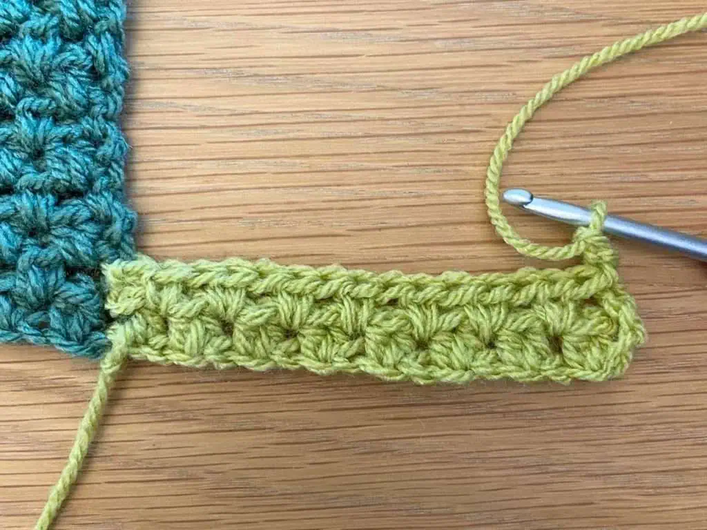 Starting the third row of crochet working with green yarn