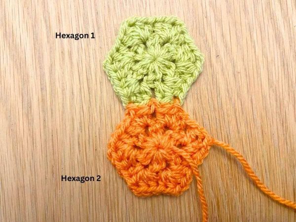 Orange crochet hexagon joined to a green crochet hexagon