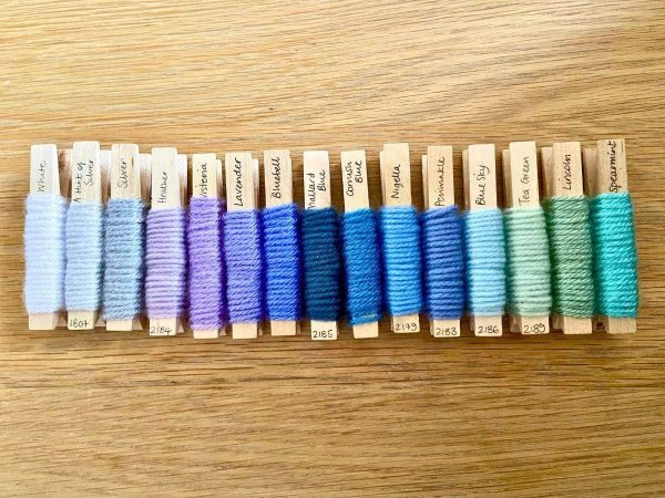 Yarn pegs in a line showing the colour scheme for the Heart Block Blanket