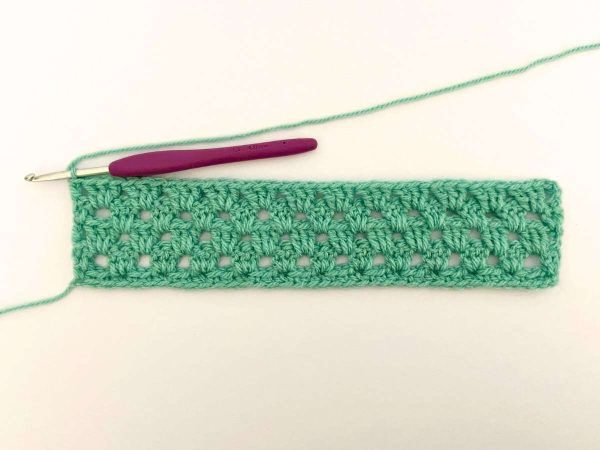 Green yarn and purple crochet hook used to indicate the fifth row of the crochet pattern