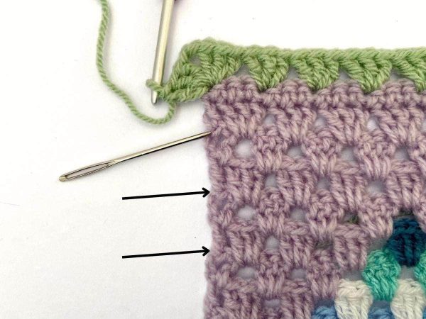 Arrows showing the placement of the crochet stitches for the border of a crochet blanket